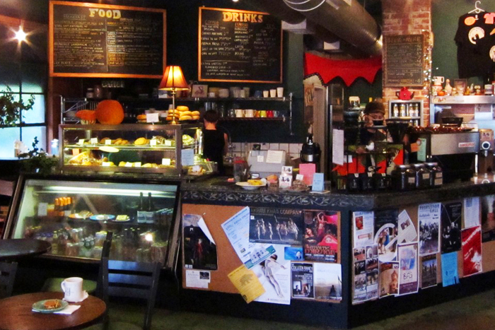 Inside Commongrounds — counter, pastry case, and chalkboard menus
