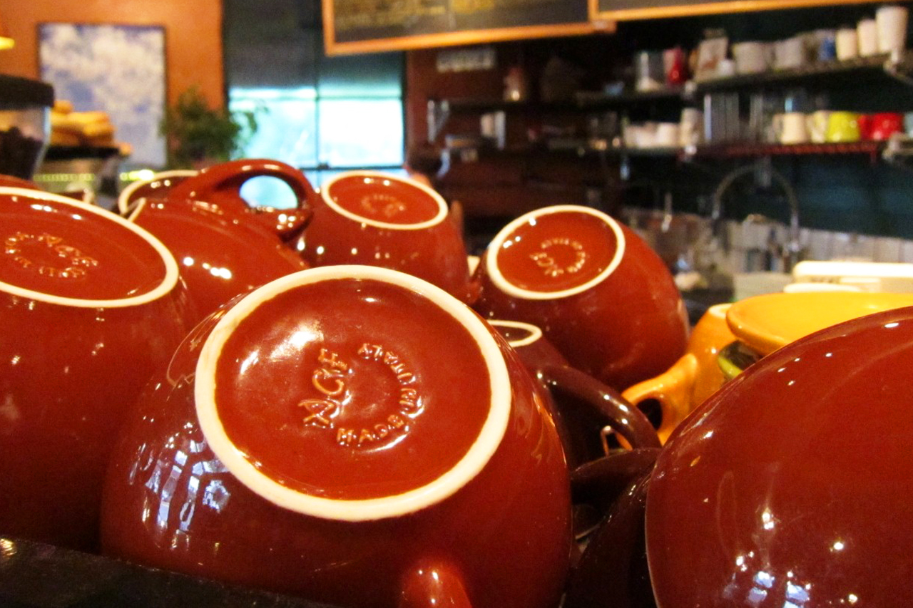 Stacked ceramic coffee mugs at the bar